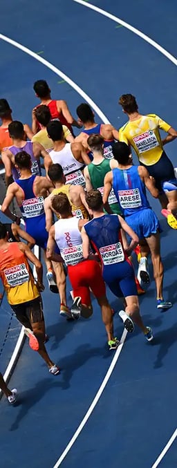 group of men running on an athletics running track